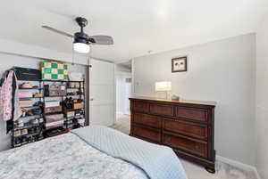 Bedroom with light carpet and a ceiling fan