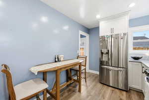 Dining area with light wood-style floors and baseboards