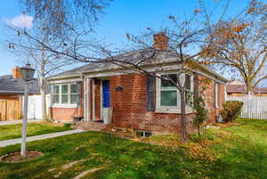 View of front of property with brick siding and a chimney