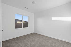 Spare room featuring baseboards and carpet