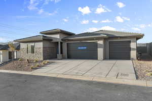 Prairie-style house featuring stucco siding, an attached garage, concrete driveway, and a tiled roof