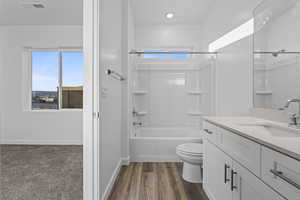 Bathroom featuring tub / shower combination, vanity, and dark wood finished floors