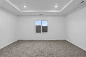 Unfurnished room with light colored carpet, recessed lighting, and a raised ceiling