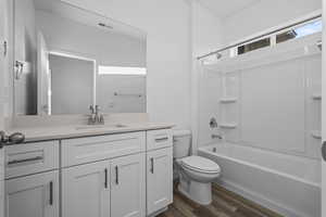 Full bathroom featuring bathtub / shower combination, vanity, and dark wood-style floors
