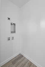 Washroom featuring light wood finished floors, hookup for a washing machine, and hookup for an electric dryer