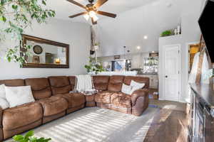 Living area featuring lofted ceiling, ceiling fan, and wood finished floors