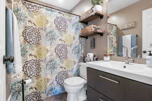 Full bath with vanity, a shower with curtain, and dark tile patterned flooring