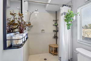 Bathroom featuring a stall shower and toilet