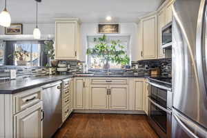 Kitchen with cream cabinetry, stainless steel appliances, healthy amount of natural light, a peninsula, and recessed lighting