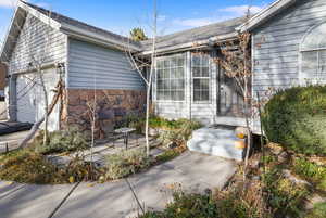 View of property exterior featuring roof with shingles, stone siding, and an attached garage