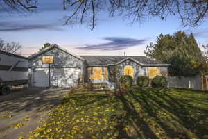 View of front of property with driveway, a front yard, and a garage