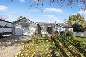 Ranch-style house featuring concrete driveway and an attached garage
