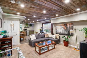 Living room with wood ceiling, carpet, crown molding, and recessed lighting