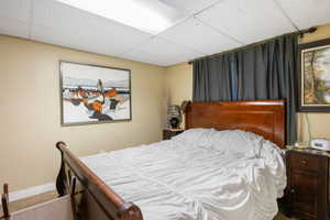 Bedroom with a paneled ceiling and carpet