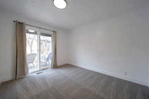 Carpeted empty room with baseboards and a textured ceiling