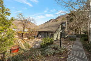 Back of property featuring roof with shingles, a patio, and a mountain view