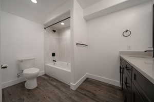 Full bathroom with vanity, dark wood-style flooring, shower / bathtub combination, and recessed lighting