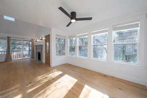 Unfurnished living room with a fireplace with flush hearth, light wood-style flooring, and ceiling fan