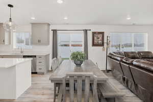 Dining area with recessed lighting and light wood-type flooring