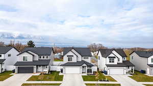 View of front of home featuring a residential view, driveway, and a shingled roof