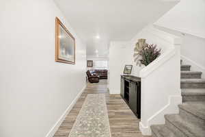 Corridor with stairway, recessed lighting, and light wood-style flooring