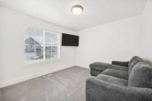 Living area with light carpet and baseboards