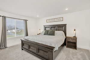 Bedroom with light colored carpet and recessed lighting