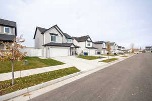Modern farmhouse with a residential view, driveway, board and batten siding, and an attached garage