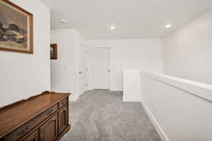 Hall featuring light carpet, an upstairs landing, and recessed lighting