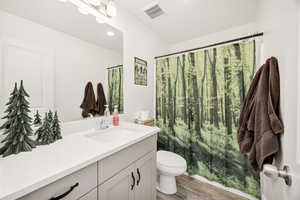 Bathroom with a shower with curtain, vanity, light wood-style flooring, and recessed lighting
