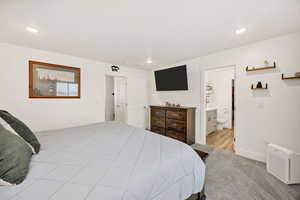 Bedroom with light carpet, recessed lighting, and ensuite bath