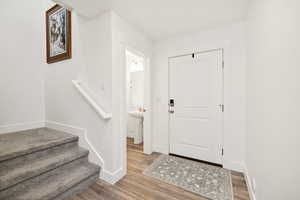 Foyer entrance featuring stairs and wood finished floors