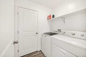 Washroom featuring dark wood-style flooring and washer and clothes dryer