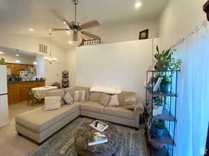 Living room with ceiling fan, lofted ceiling, recessed lighting, and a chandelier