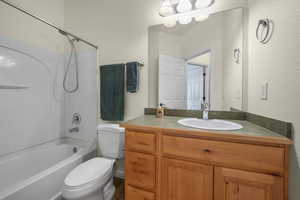 Bathroom with bathtub / shower combination, a textured wall, and vanity