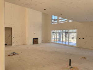 Unfurnished living room featuring a towering ceiling