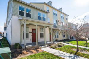View of front facade featuring covered porch, a front lawn, and stucco siding