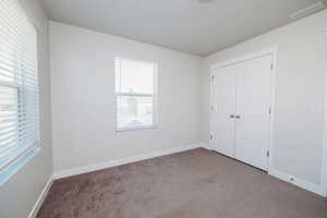 Unfurnished bedroom featuring carpet floors and a closet
