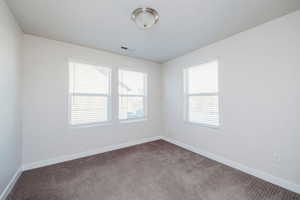 Spare room featuring baseboards and carpet floors