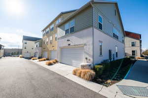 View of home's exterior featuring stucco siding, an attached garage, and driveway