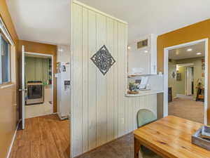 Hall with washer / clothes dryer and light wood-type flooring