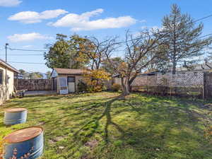 Fenced backyard featuring an outdoor structure