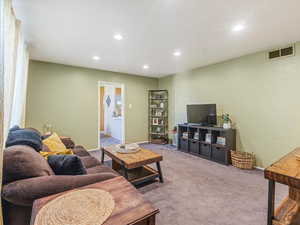 Carpeted living room with recessed lighting and baseboards