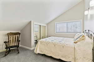 Bedroom featuring lofted ceiling and carpet floors