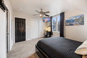 Bedroom with a desk, carpet flooring, a closet, and a ceiling fan