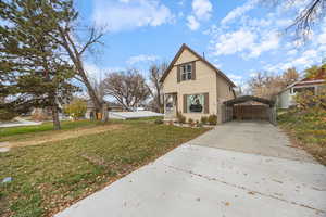 View of front of house with a front yard, driveway, and a carport