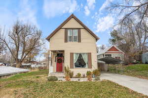 View of front of property with a carport, a front yard, and driveway