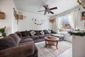 Living area featuring wood finished floors and ceiling fan