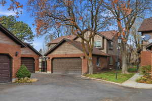 View of front of house featuring brick siding, driveway, and a garage