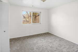 Carpeted spare room with baseboards